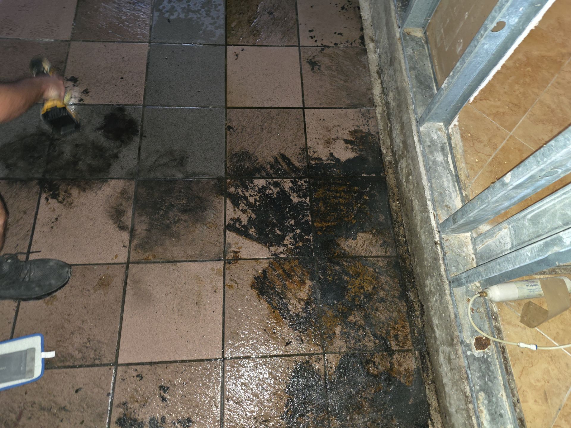 Technician scrubbing soot and smoke residue from tile floor